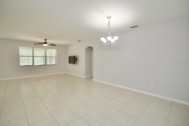 tiled spare room featuring ceiling fan with notable chandelier