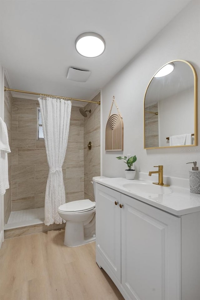 bathroom featuring hardwood / wood-style flooring, toilet, vanity, and a shower with shower curtain