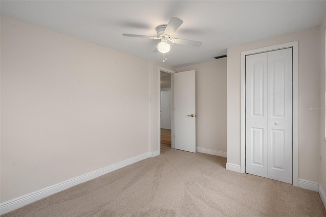 unfurnished bedroom with a closet, ceiling fan, and light colored carpet