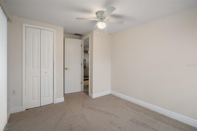 unfurnished bedroom with a closet, ceiling fan, and light colored carpet