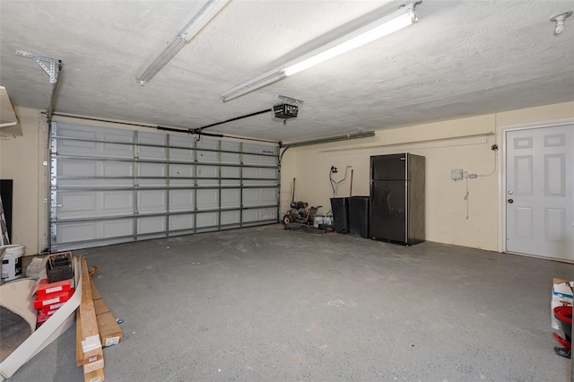 garage with black fridge and a garage door opener