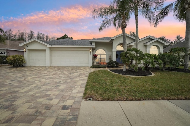 view of front facade with a garage and a lawn