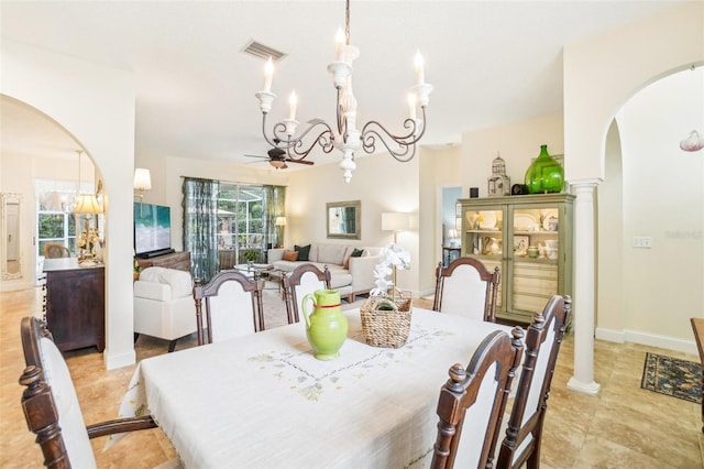 dining space with ceiling fan with notable chandelier and ornate columns