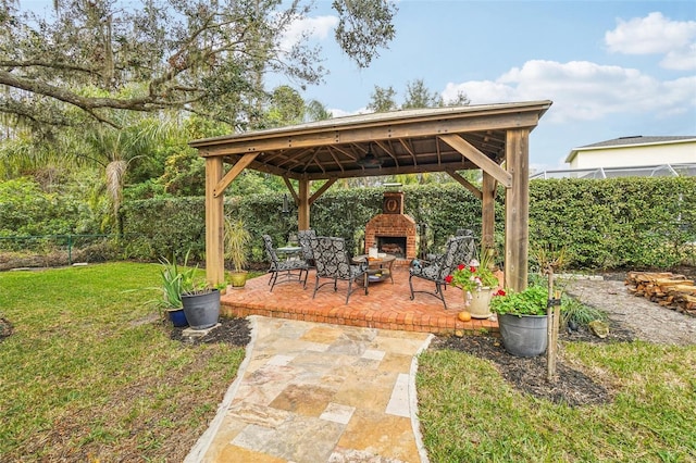 view of patio / terrace featuring exterior fireplace and a gazebo