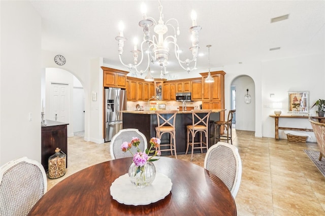 dining area featuring light tile patterned floors and an inviting chandelier