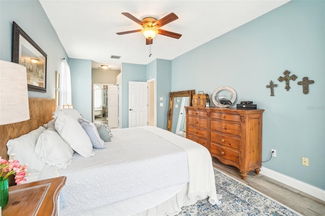 bedroom featuring ensuite bathroom, light hardwood / wood-style flooring, and ceiling fan