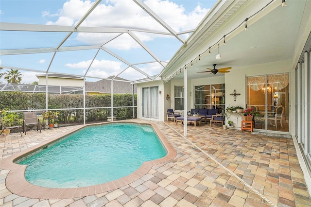 view of pool with ceiling fan, glass enclosure, outdoor lounge area, and a patio area