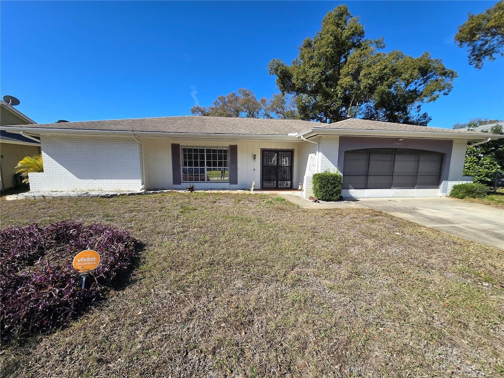 ranch-style house with a garage and a front lawn