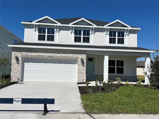 view of front of property with a porch, concrete driveway, stone siding, and an attached garage