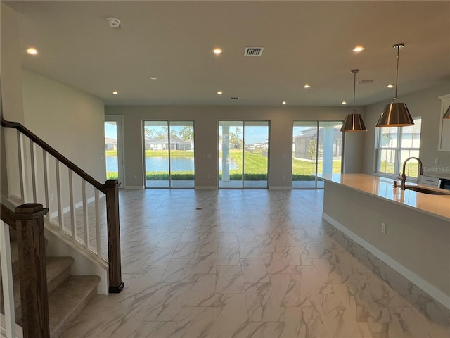 unfurnished living room featuring marble finish floor, visible vents, a sink, and recessed lighting