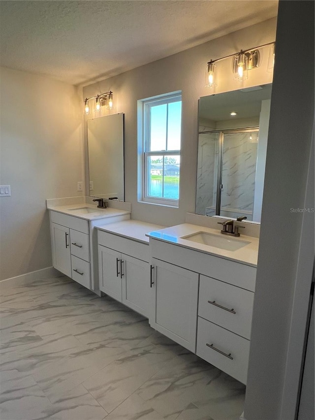 full bath with a marble finish shower, baseboards, marble finish floor, a textured ceiling, and vanity