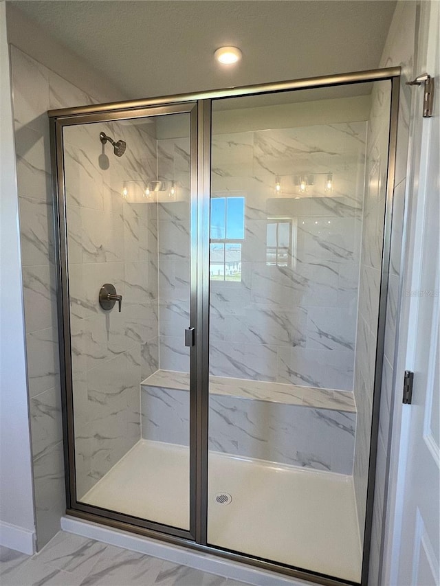 bathroom with marble finish floor and a marble finish shower