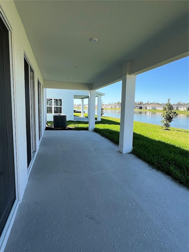 view of patio / terrace with a water view and central AC unit