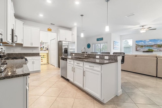 kitchen featuring white cabinetry, an island with sink, and sink