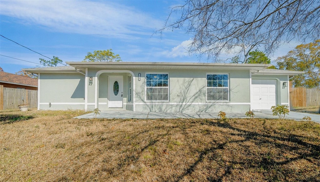 single story home with a garage and a front lawn