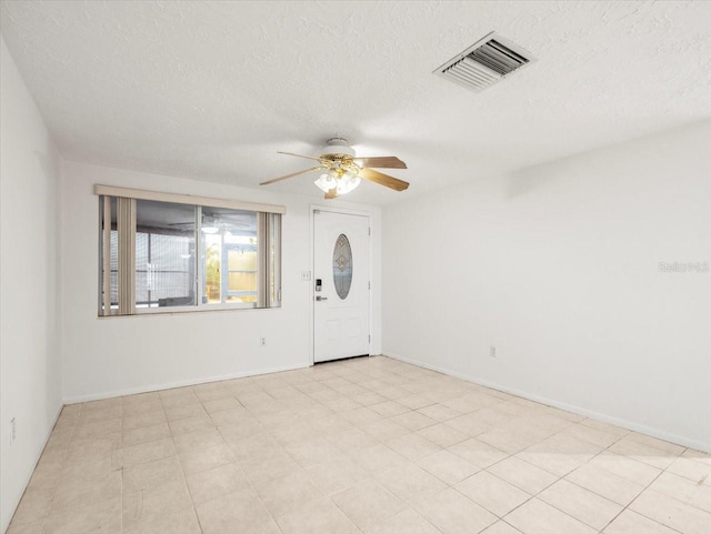 unfurnished room featuring ceiling fan and a textured ceiling