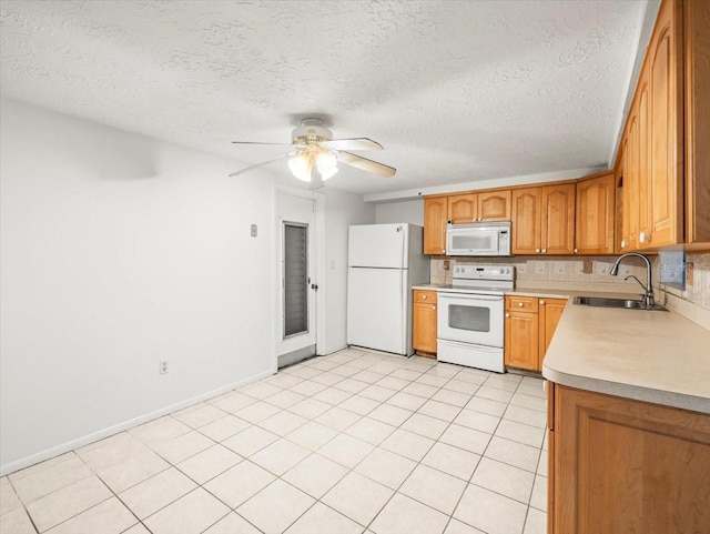 kitchen featuring white appliances, a textured ceiling, sink, light tile patterned flooring, and ceiling fan