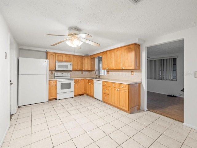 kitchen with white appliances, a textured ceiling, sink, ceiling fan, and light tile patterned floors