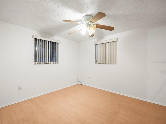 unfurnished room featuring hardwood / wood-style flooring, ceiling fan, and a textured ceiling