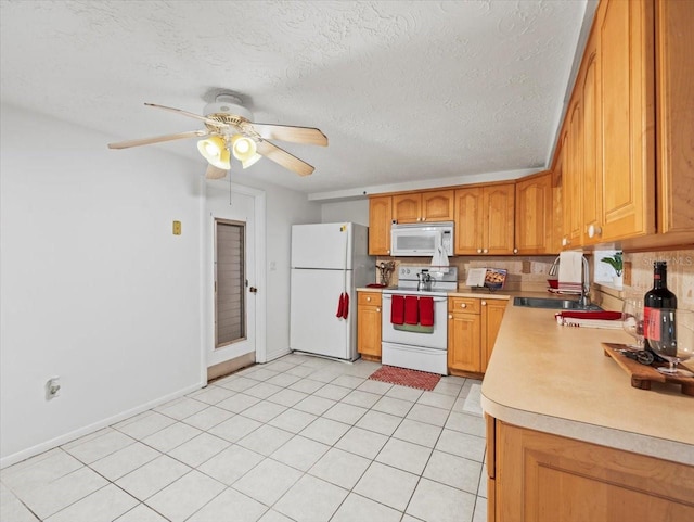 kitchen with sink, white appliances, ceiling fan, a textured ceiling, and decorative backsplash