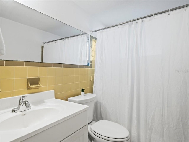 bathroom with vanity, tile walls, and toilet