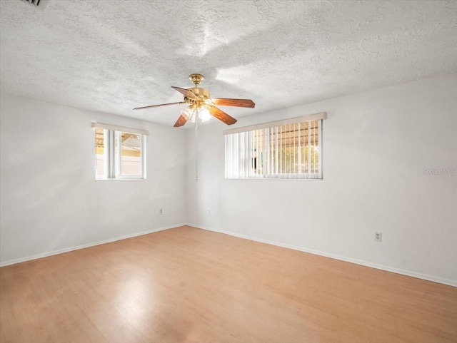 empty room featuring ceiling fan, a textured ceiling, and light wood-type flooring