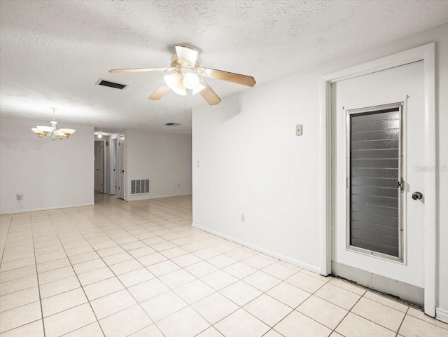 spare room with ceiling fan with notable chandelier, a textured ceiling, and light tile patterned flooring