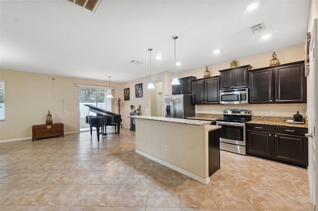 kitchen featuring pendant lighting, light tile patterned floors, stainless steel appliances, light stone counters, and a kitchen island