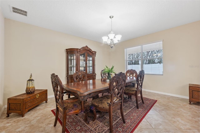 tiled dining space featuring an inviting chandelier