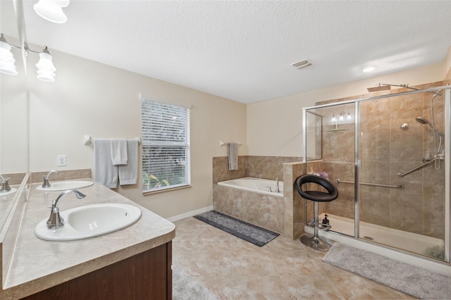 bathroom featuring vanity, tile patterned flooring, plus walk in shower, and a textured ceiling