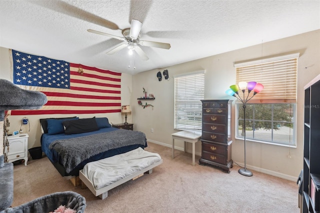 carpeted bedroom featuring a textured ceiling and ceiling fan