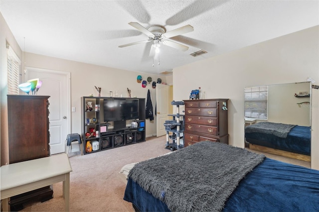 carpeted bedroom featuring a textured ceiling and ceiling fan