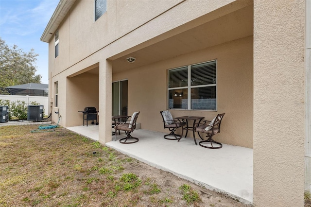 rear view of property featuring a patio, central AC, and a lawn