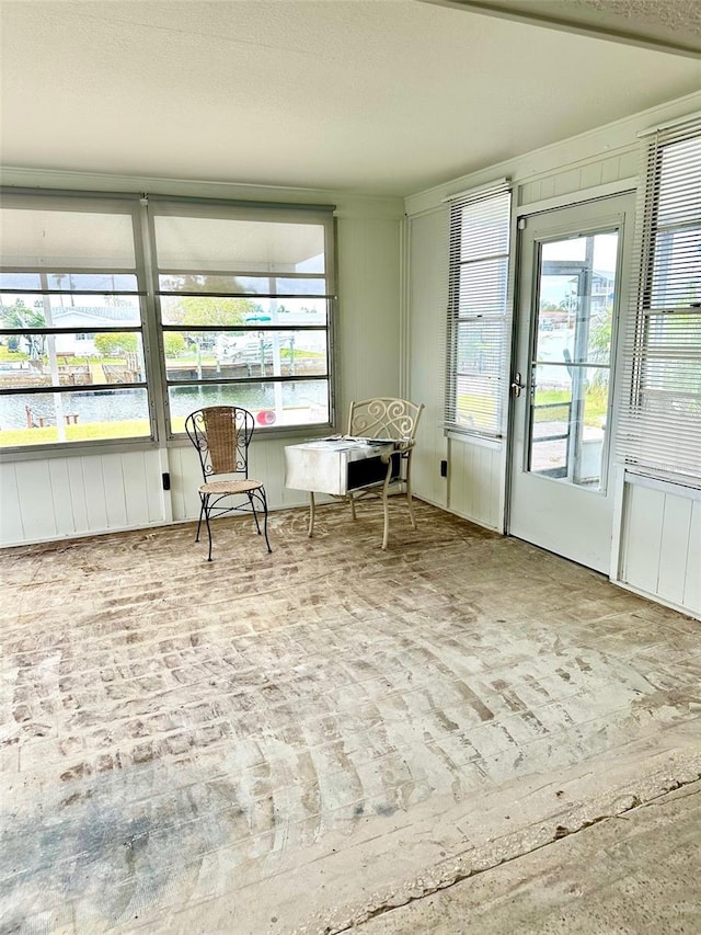 sunroom featuring a water view