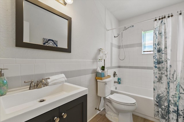 full bathroom with shower / bath combo with shower curtain, vanity, toilet, and tile walls