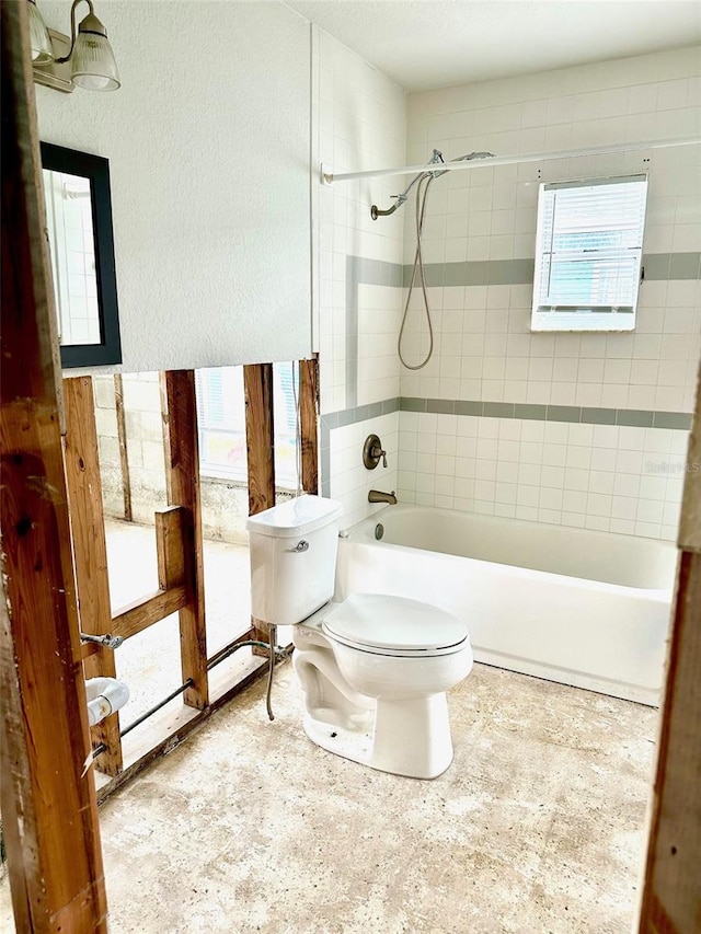 bathroom featuring tiled shower / bath and toilet