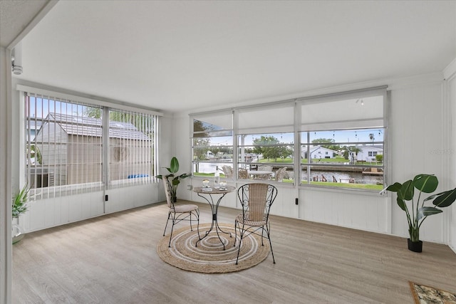 sunroom / solarium featuring a water view and plenty of natural light