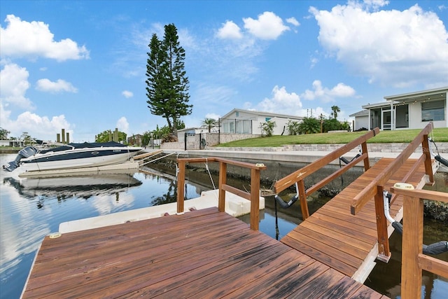 view of dock featuring a water view and a lawn