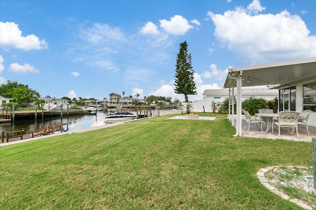 view of yard featuring a water view, a dock, and a patio area