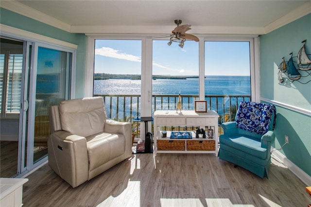 sunroom featuring a water view