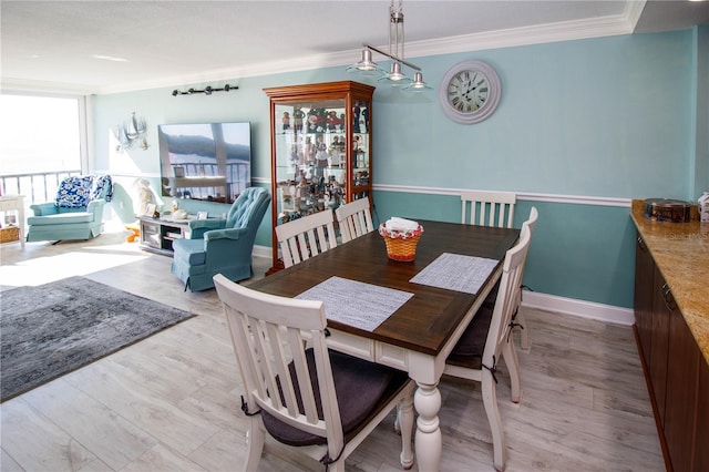 dining space featuring light hardwood / wood-style flooring and ornamental molding