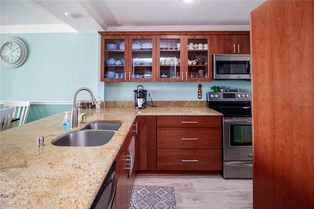 kitchen with sink, light stone counters, stainless steel appliances, crown molding, and light wood-type flooring