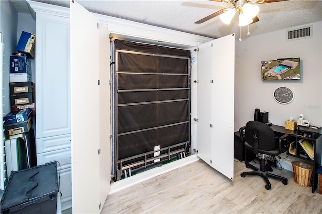 office featuring ceiling fan, light hardwood / wood-style flooring, and a textured ceiling