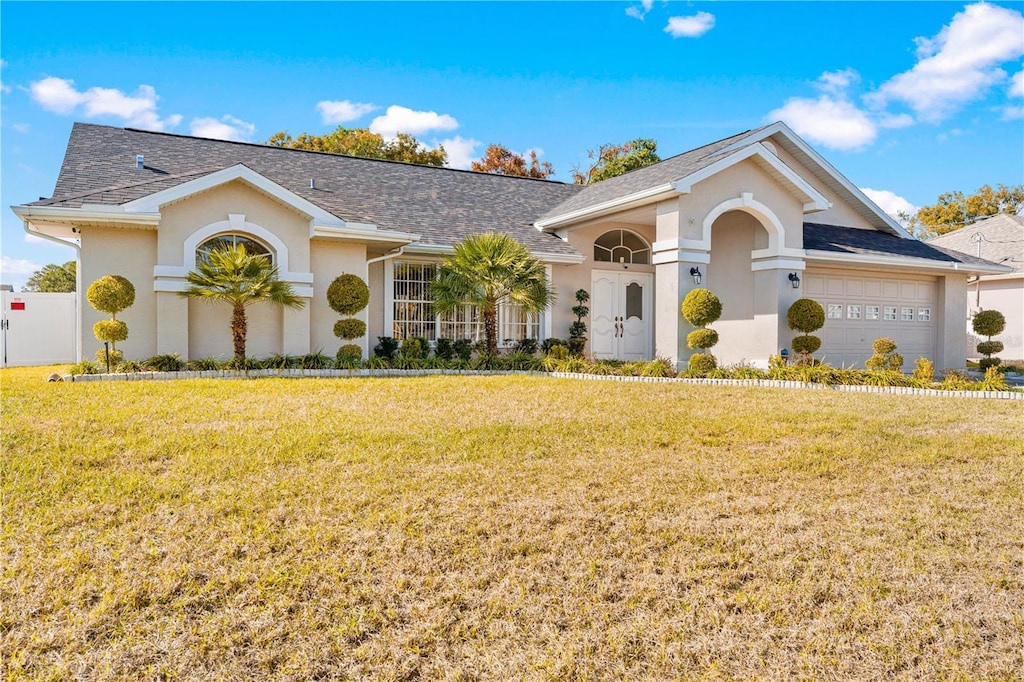 single story home featuring a garage and a front yard