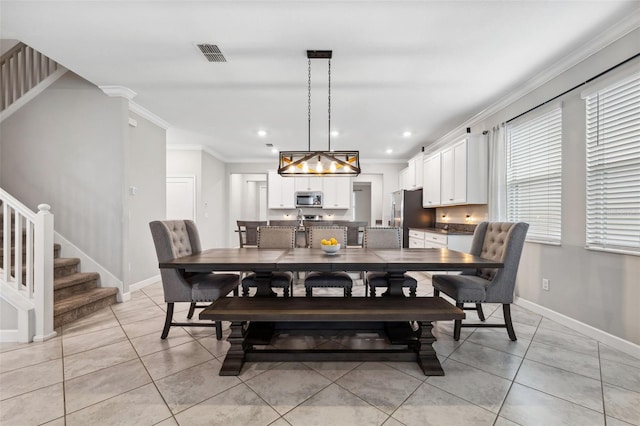 tiled dining area featuring crown molding