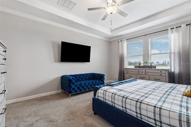 carpeted bedroom featuring ceiling fan and a tray ceiling