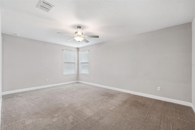 spare room with a textured ceiling, carpet floors, and ceiling fan