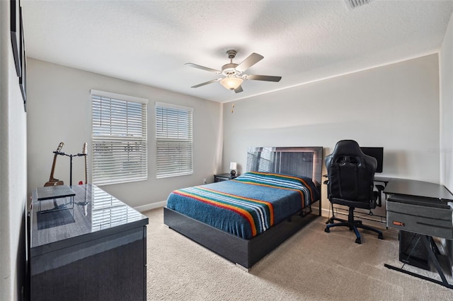 bedroom with ceiling fan, carpet floors, and a textured ceiling