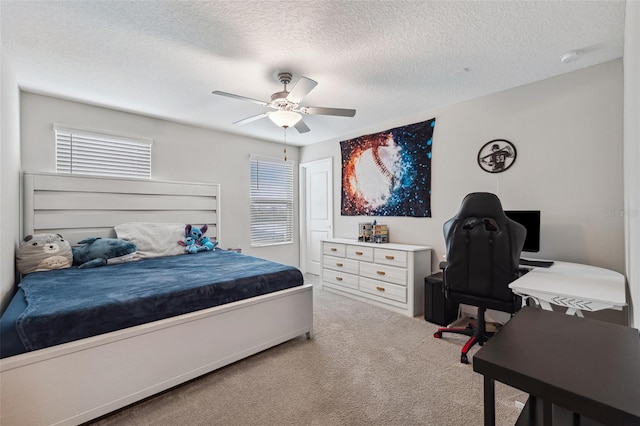 carpeted bedroom featuring ceiling fan, multiple windows, and a textured ceiling