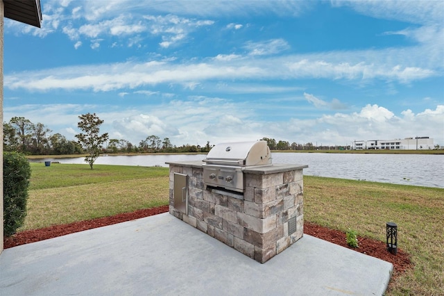 view of patio / terrace with a water view, an outdoor kitchen, and area for grilling